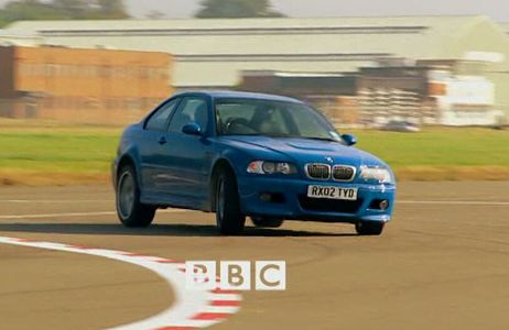 The Stig driving a blue BMW M3.