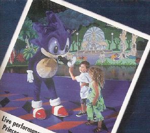 Scan of the boy head fived Sonic on stage. The set for the show is visible in the background.
