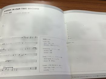 Inside of the jacket, with lyrics, definitions and sheet music in English and Japanese for "A Week in Our Time Machine". Please note that text and sheet music has been blurred out by the original uploader.