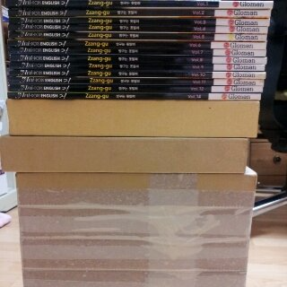 A stack of volumes of TV Ani•POPS English 21: Zzang-gu by Gloman. It is known that at least 24 volumes exist.