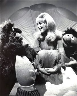 A still showing Barbara Eden with Bert, Ernie and Herry Monster.