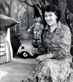 Production photo showing Enid Blyton (creator of the Noddy series) posing with a Noddy Puppet.