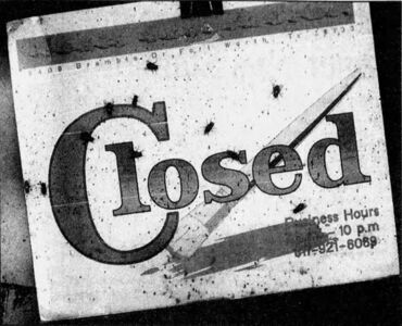 A close-up of the closed sign from the abandoned Mexia Supermarket.