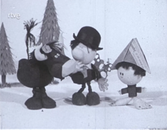 A black and white image wich shows Mumú, a bull with messy hair and a flower on his head. Besides him, there's an adult man named D. Tontón with buck teeth and short hair wearing a round-topped hat, next to them, theres a small girl named Lolita with short, curly hair, wearing a sweater and a triangle-shaped hat made out of newspaper.