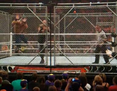 Undertaker throwing Cena into the cage wall.