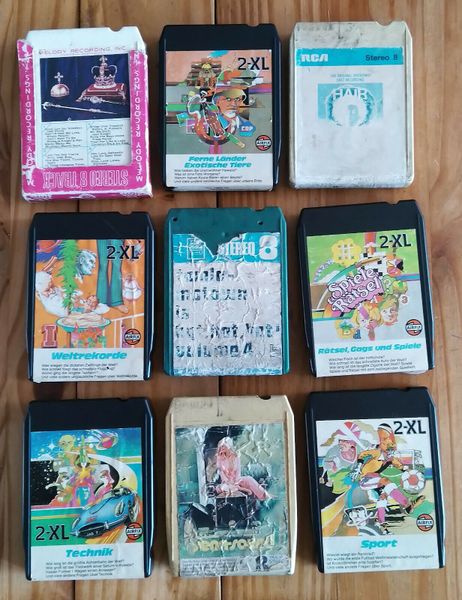 This photo, taken from eBay, shows a selection of five Mego 2-XL tapes that were released in Germany: "Ferne Länder Exotische Tiere" (Distant countries Exotic animals), "Sports" (Sport), "Welktrekorde" (World Records), "Rätsel, Gags, und Spiele" (Puzzles, gags, and games), and "Technik" (Technology). It also showcases some of the changes to U.S. cover art when it was re-used for the German market.