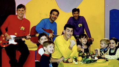 The photo of The Wiggles and kids at a table of food.