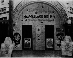 The front of a theatre showing the movie.