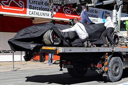 The McLaren was covered up and transported back to the pits.